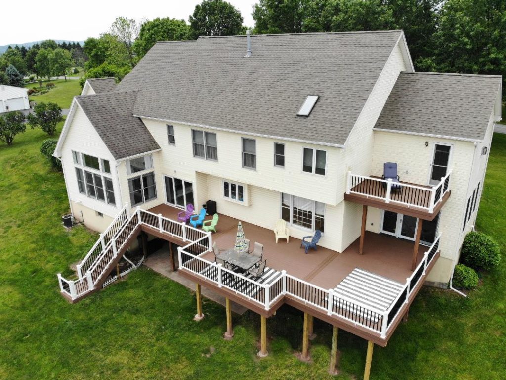 Drone view of a brown deck with white and black fencing.
