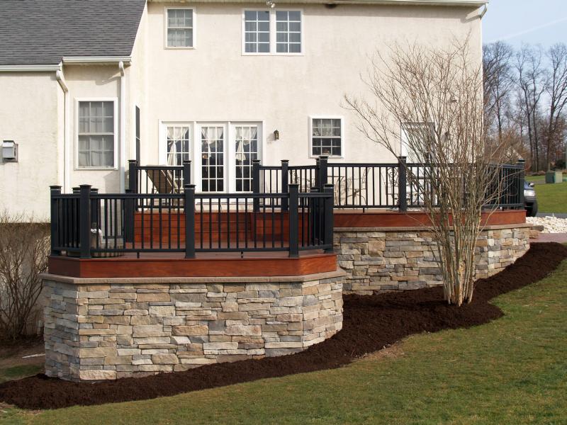 Alternate style deck with stone and black fences from McHenry Deck Builders.