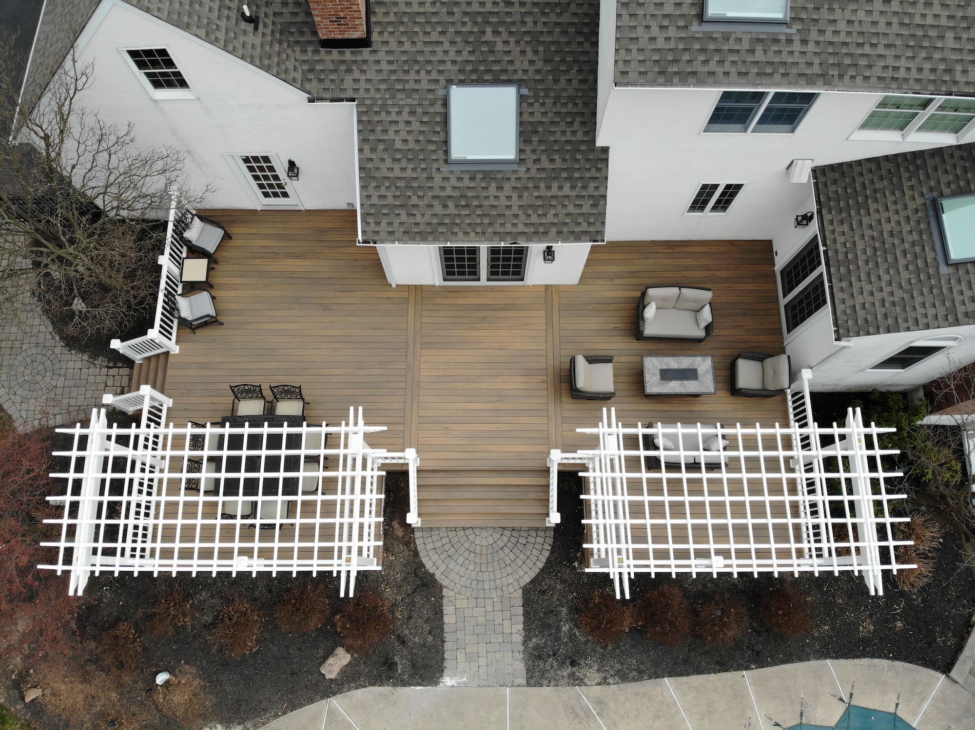 View of a deck that is fully furnished with white fencing from above.