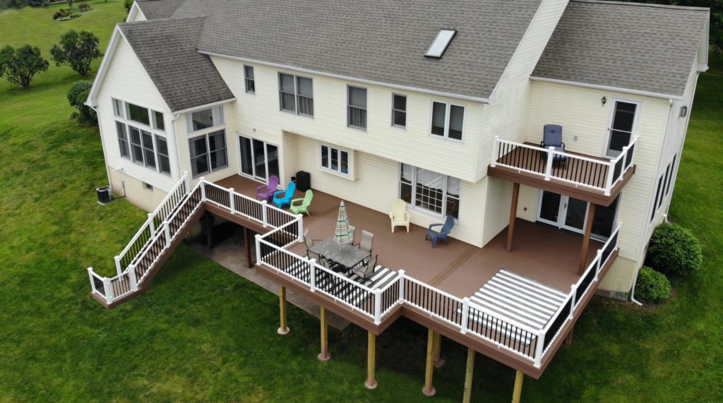 Brown deck with white and black fencing view from a drone in the air.